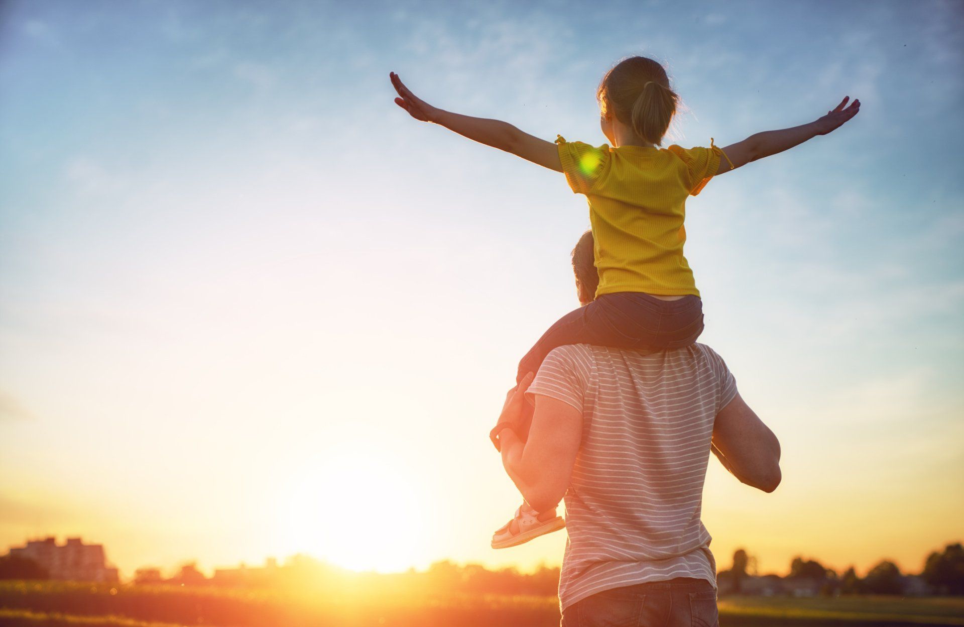 child on fathers shoulders