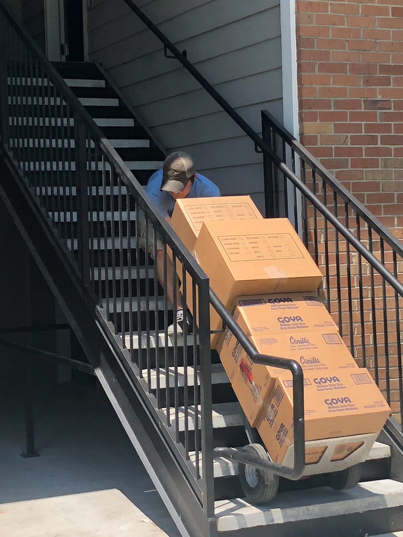 jr brown employee navigating down stairs with belongings