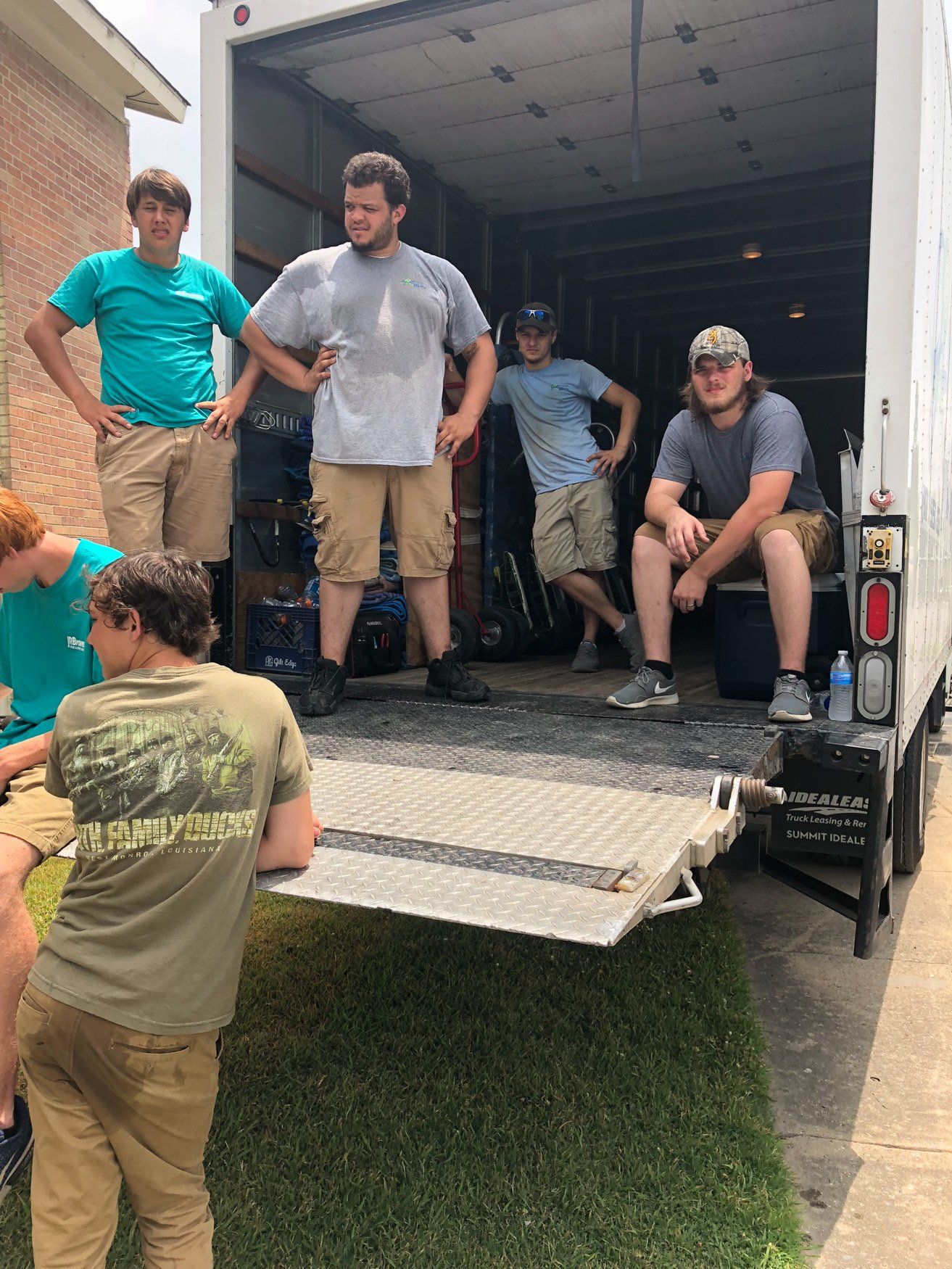 jr brown employees taking a short break on back of truck