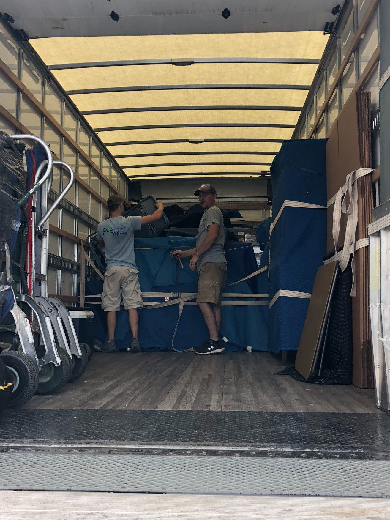Two men are loading furniture into a moving truck.