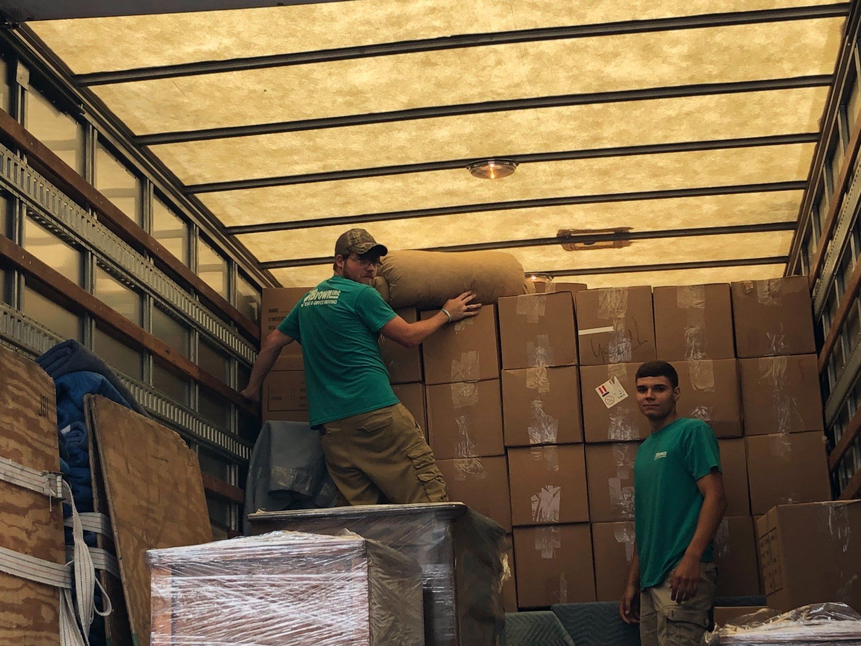 Two men are loading boxes into a truck.