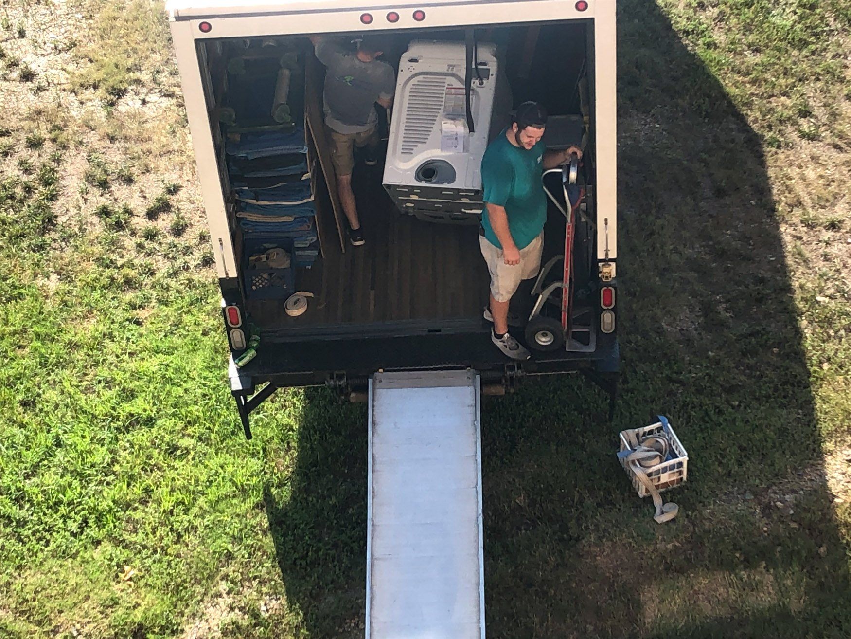 A man is standing in the back of a moving truck.