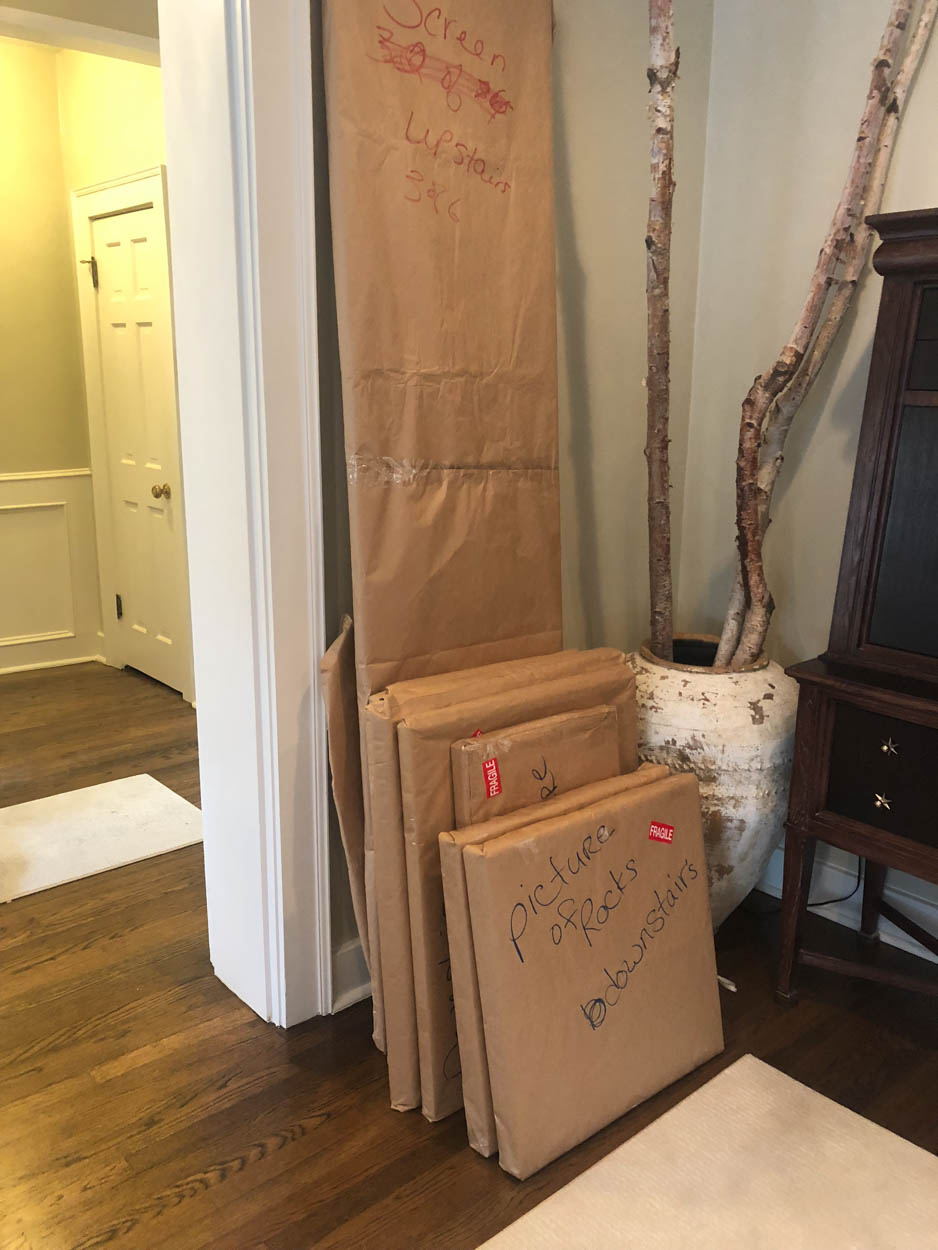 A stack of boxes wrapped in brown paper in a living room.