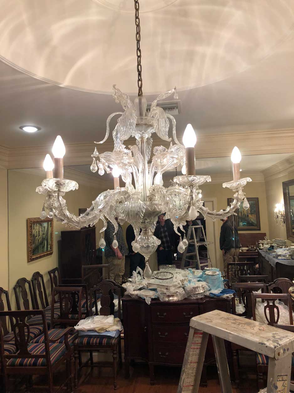 A large chandelier is hanging from the ceiling in a living room.
