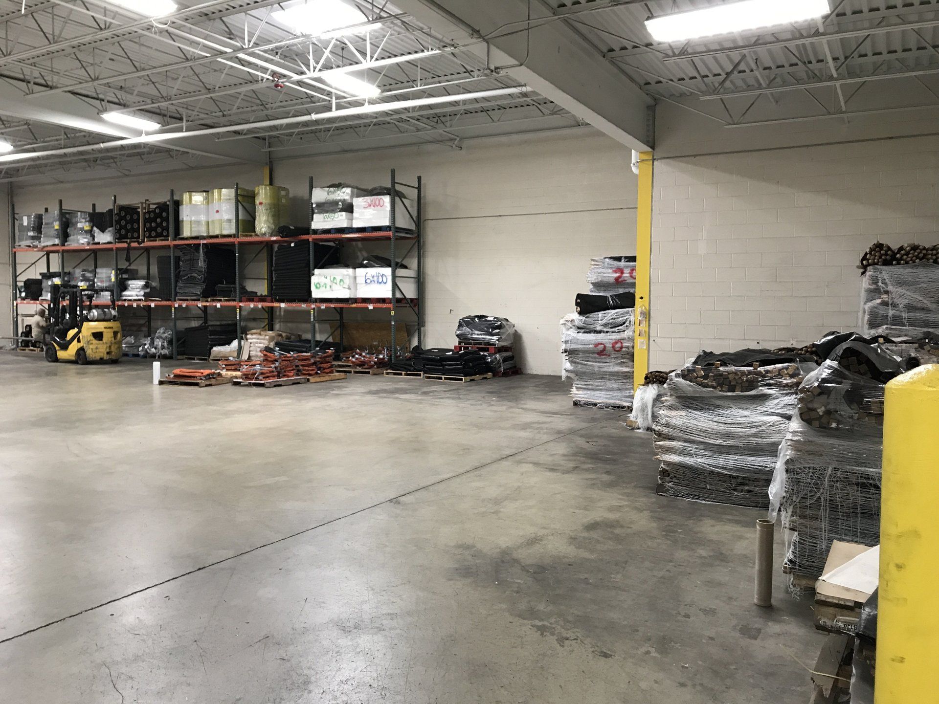 There is a forklift in the middle of the warehouse.