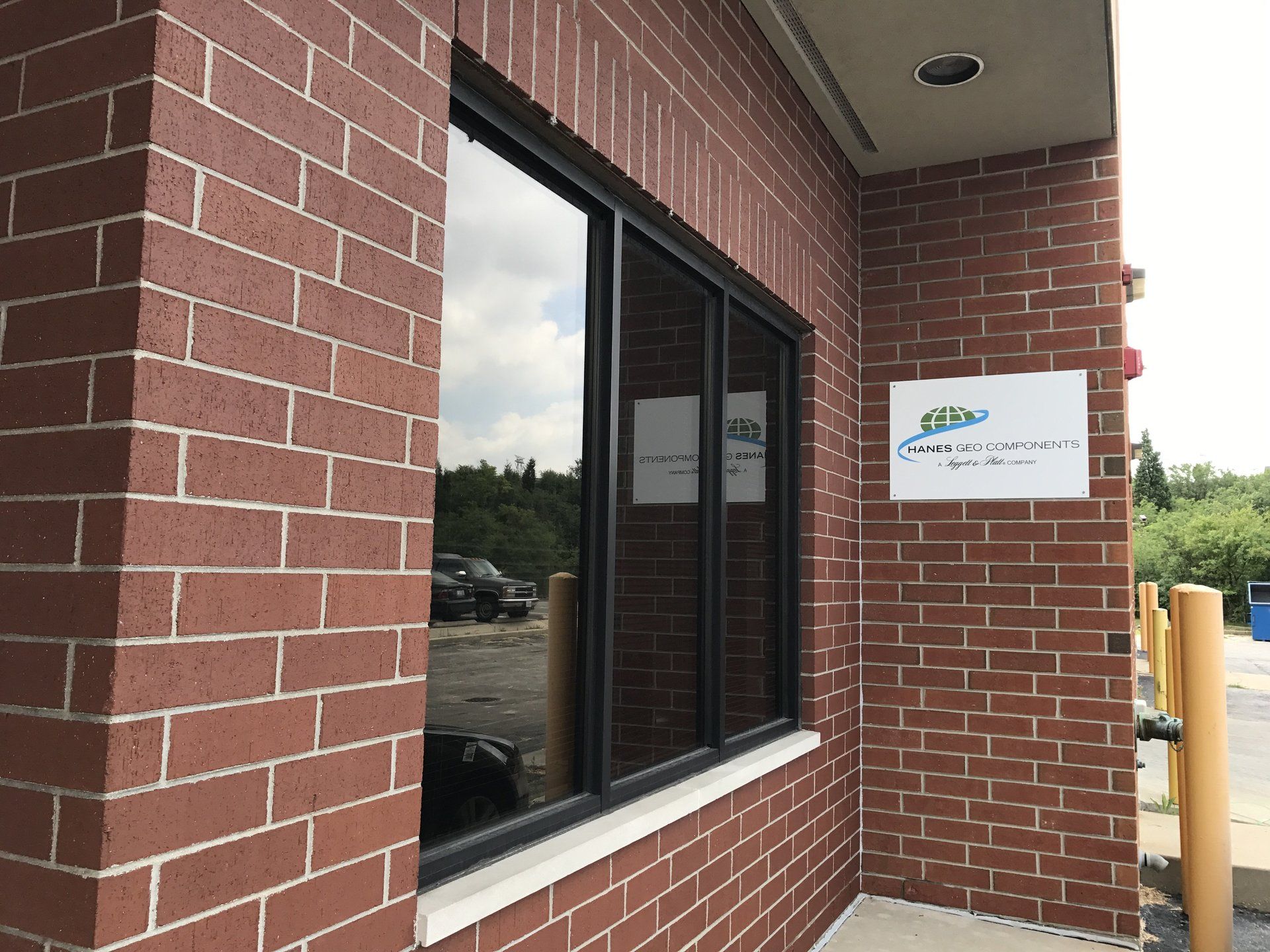 A brick building with a window and a sign on it