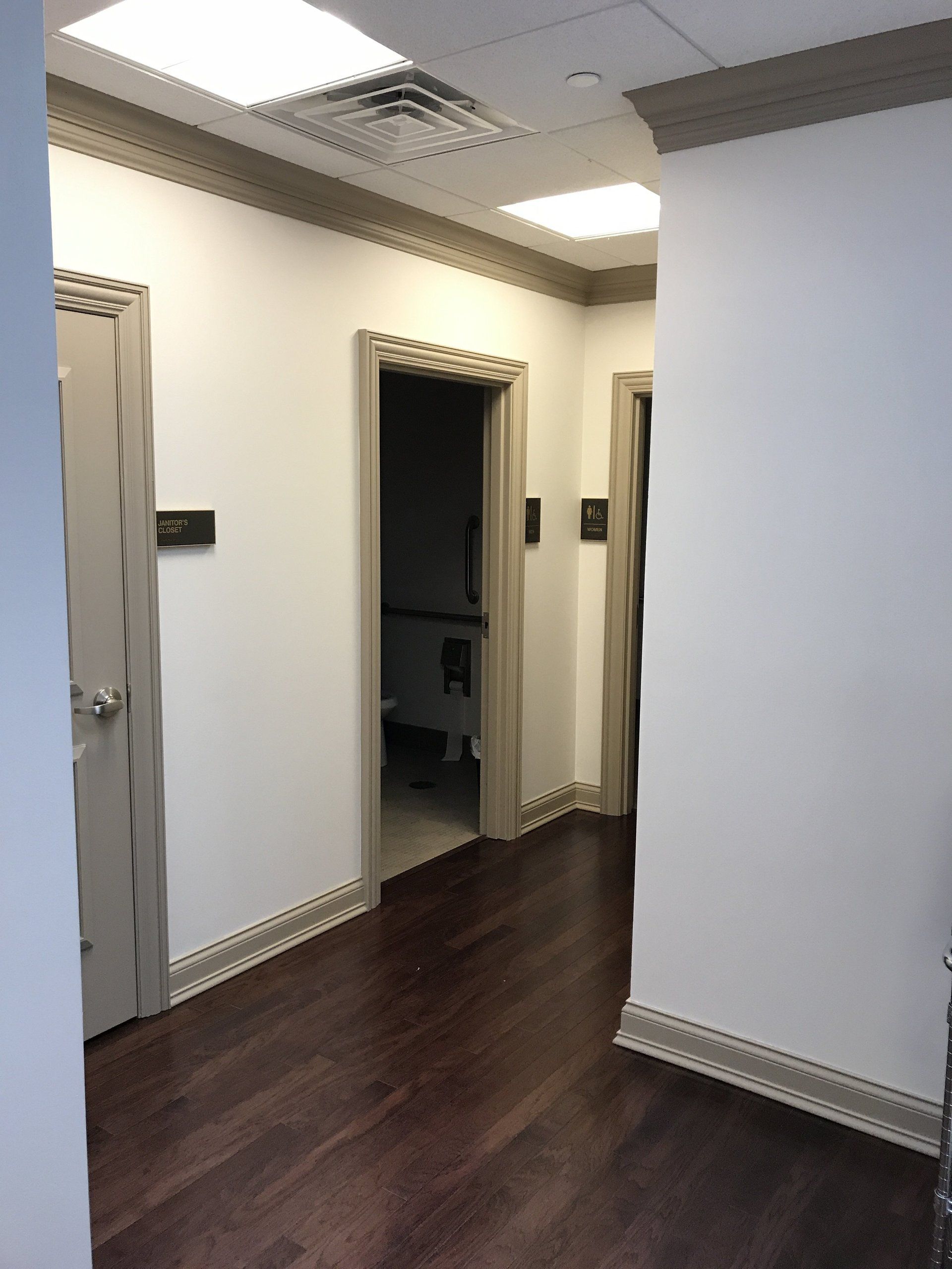 A hallway with wooden floors and white walls