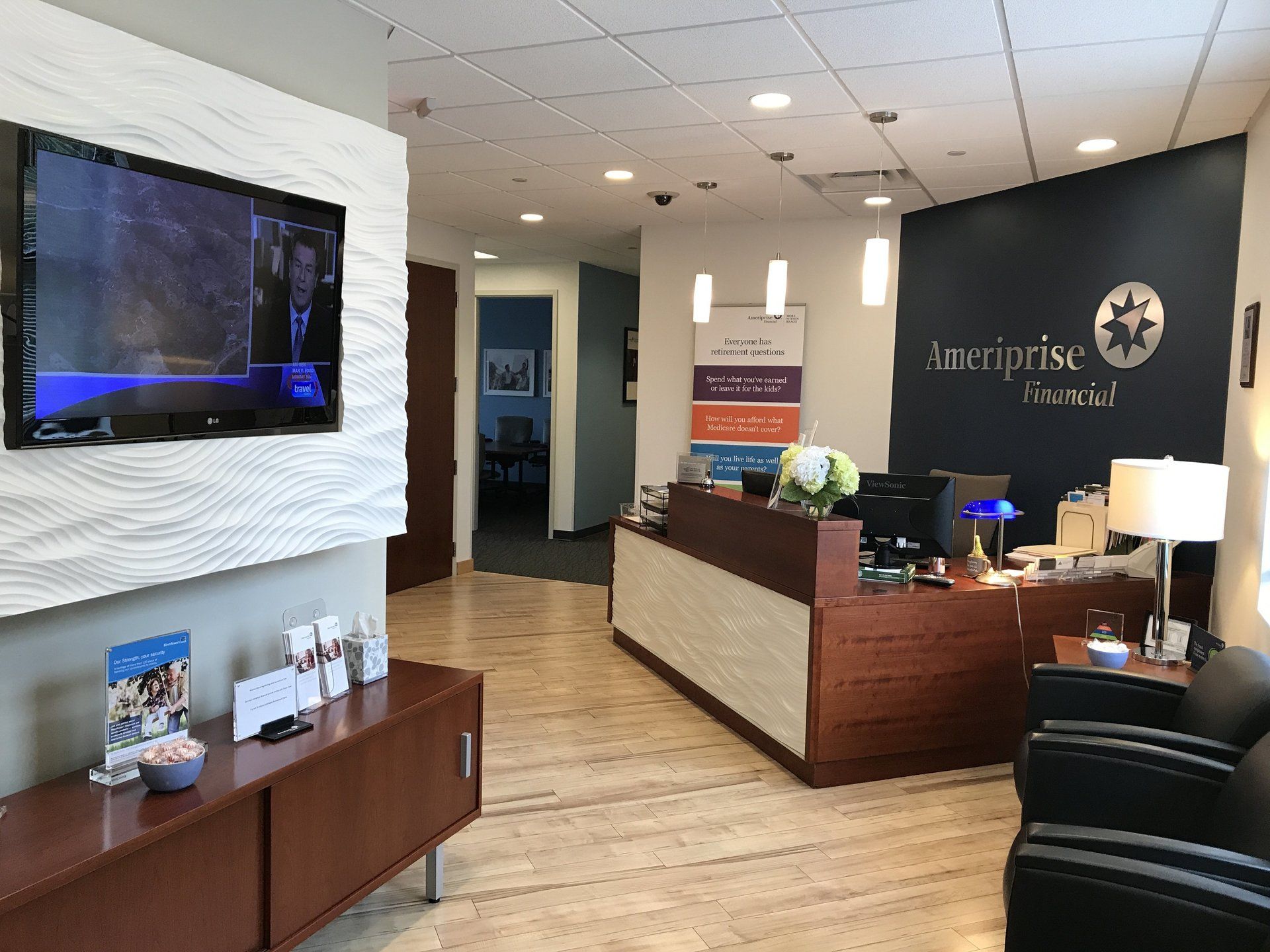 A reception area with a large flat screen tv on the wall.