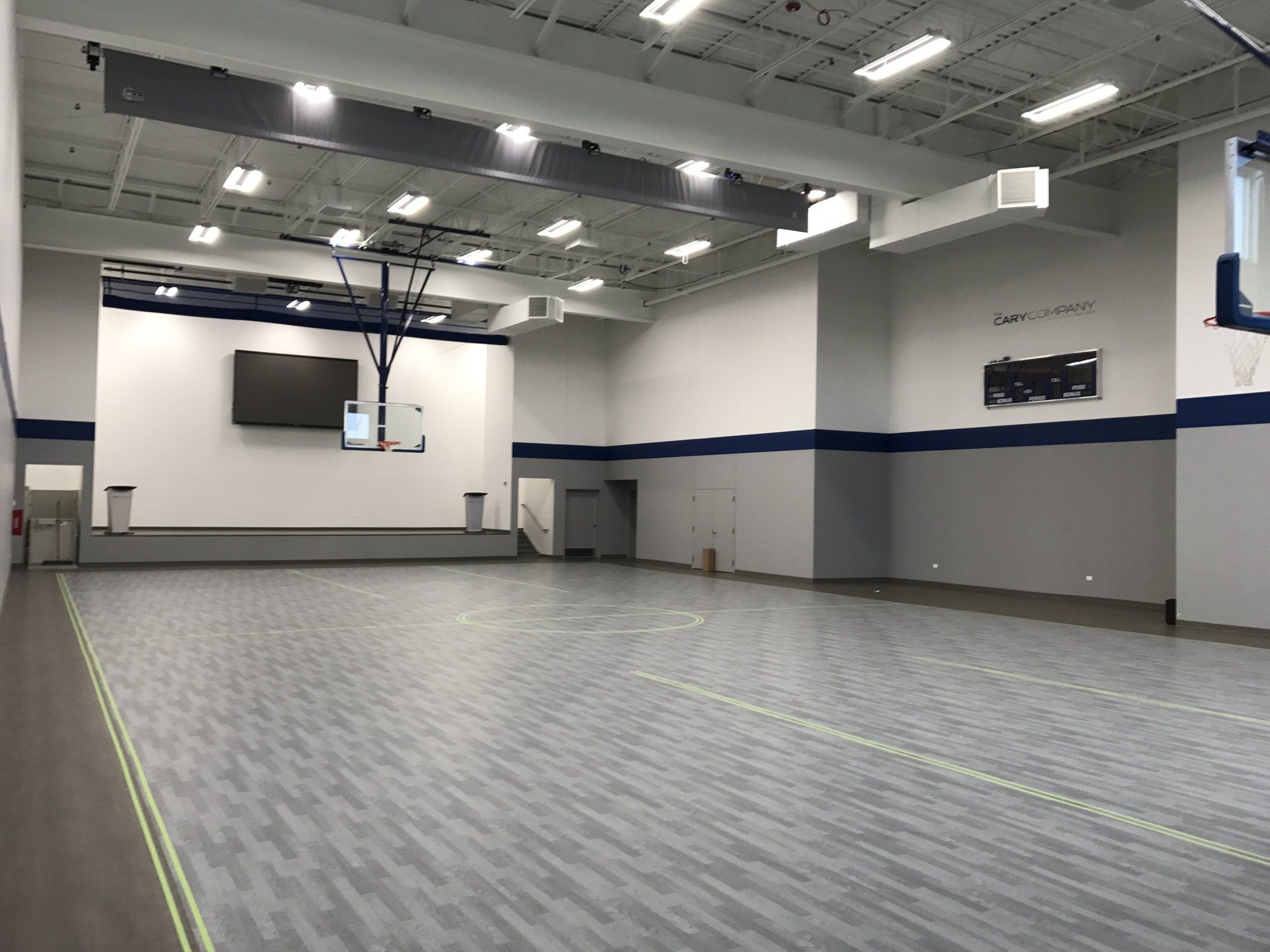 There is a basketball hoop in the middle of the gym.