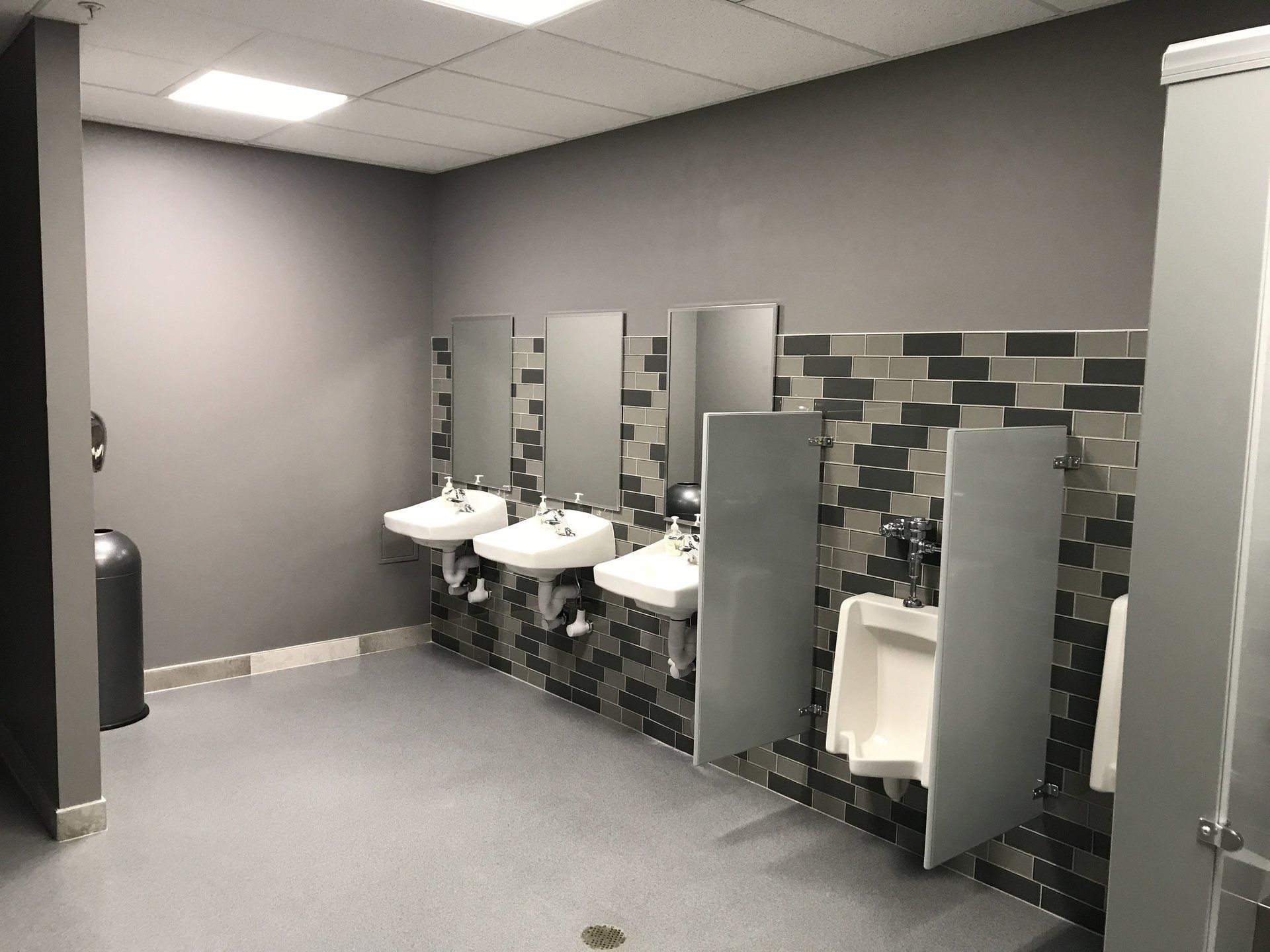 A public restroom with a row of sinks and urinals.