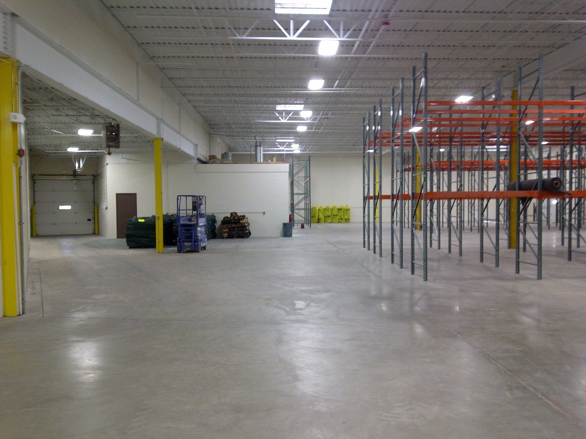 An empty warehouse with shelves and a forklift