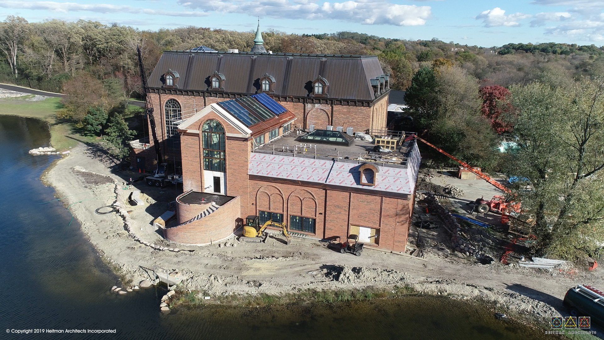 An aerial view of a large brick building next to a body of water.