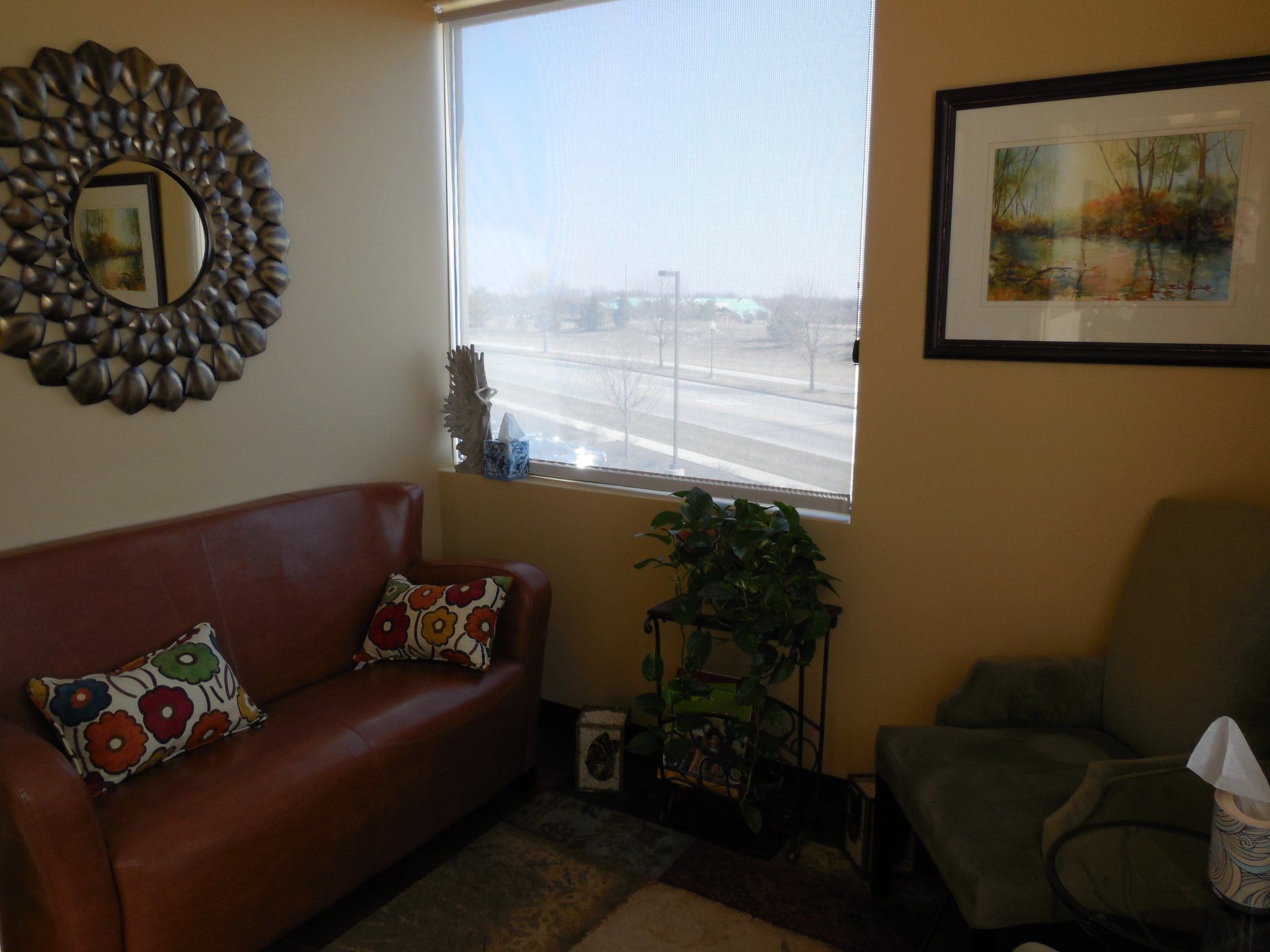 A living room with a couch a chair and a mirror