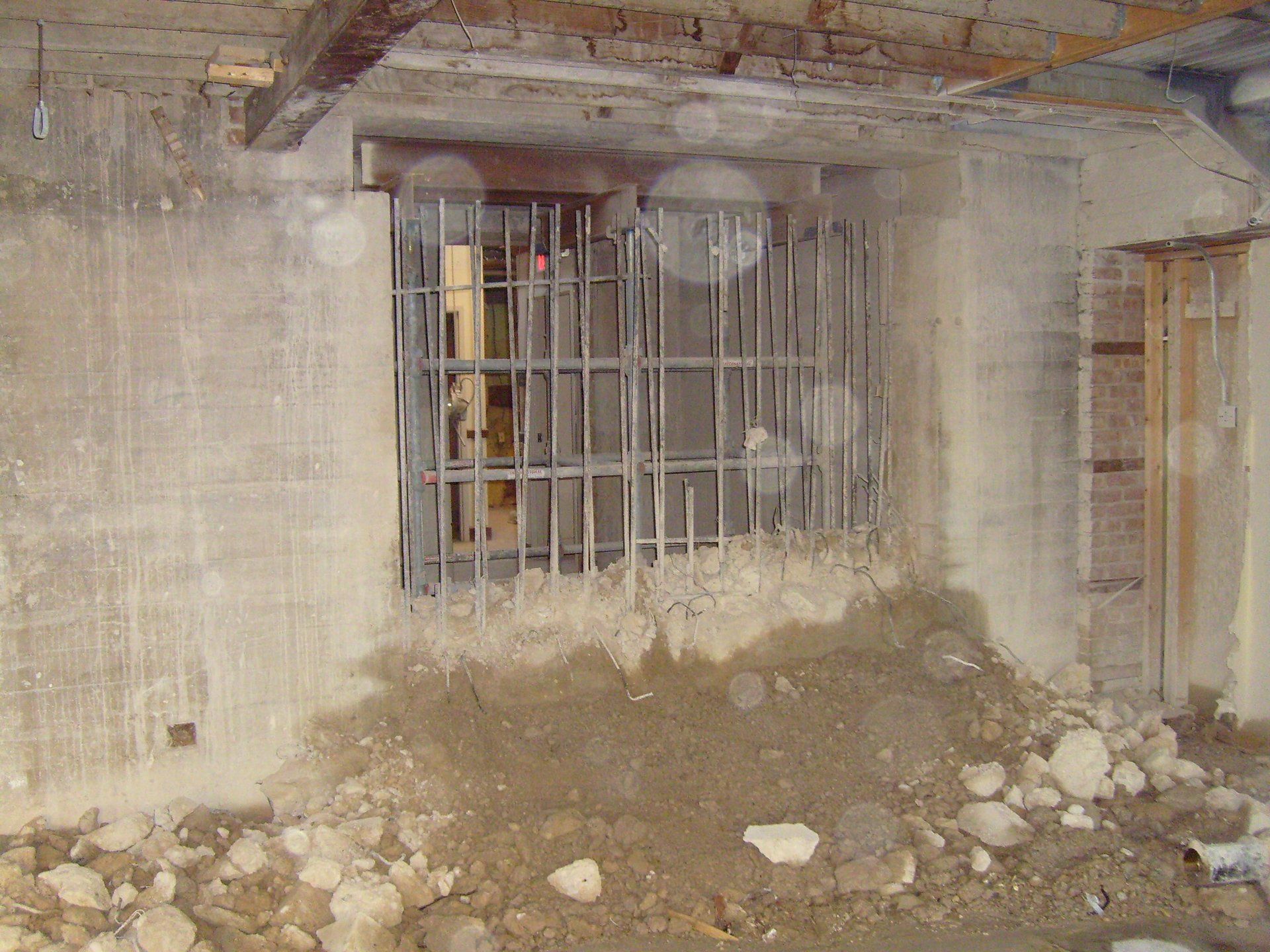 A dirty room with a window with bars on it