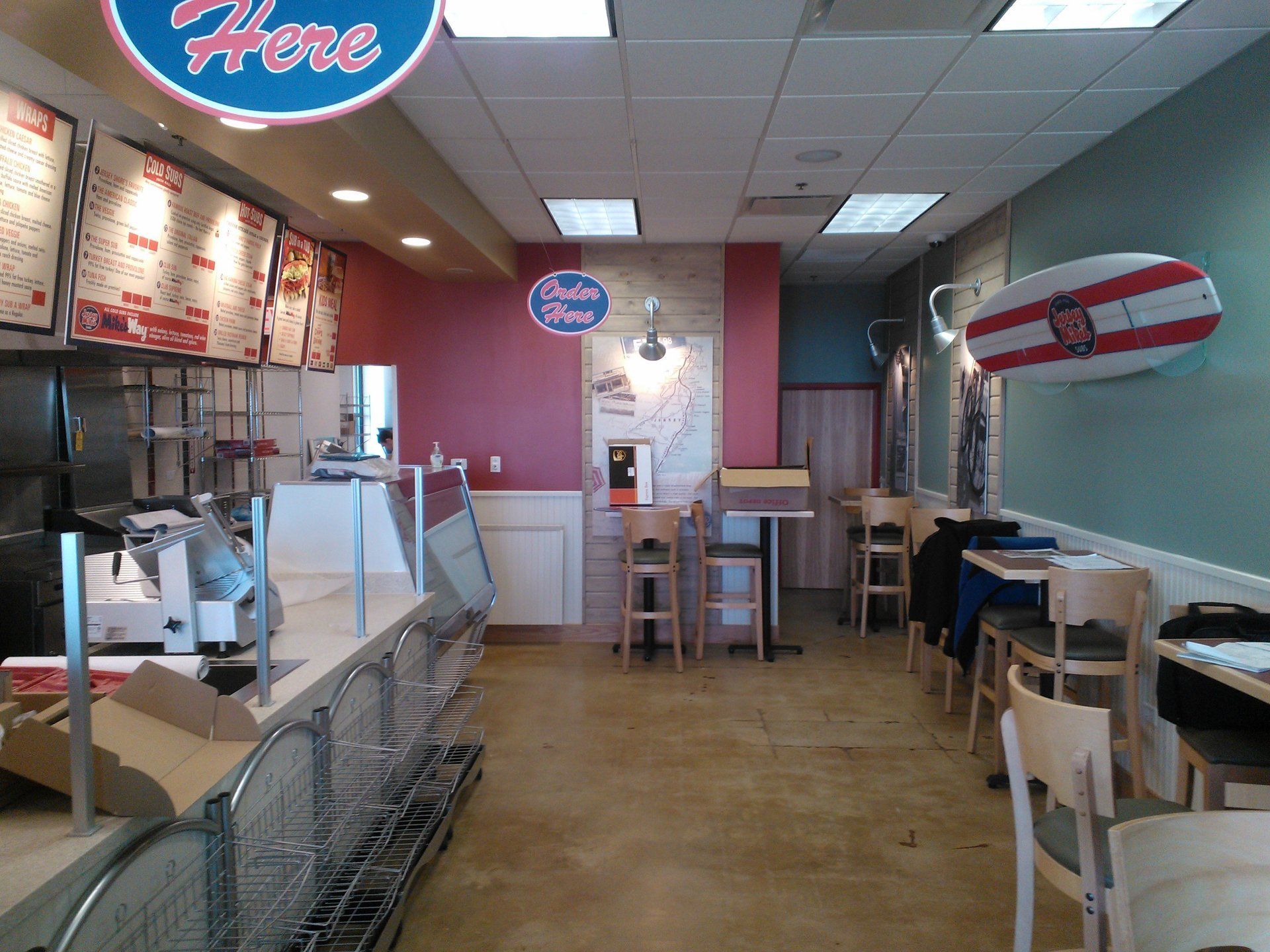 The inside of a restaurant with a sign that says here