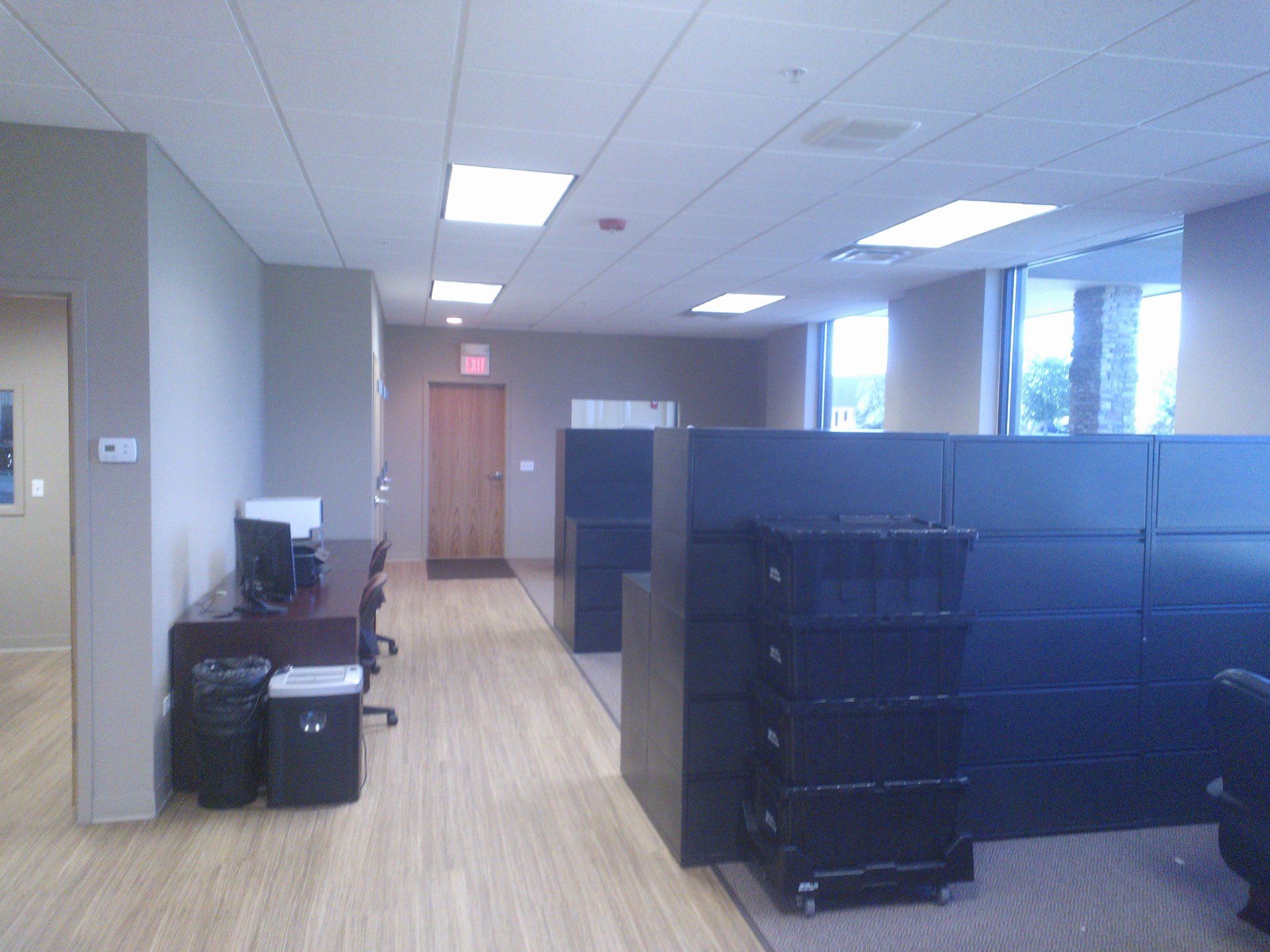 An office with cubicles and a stack of trash cans