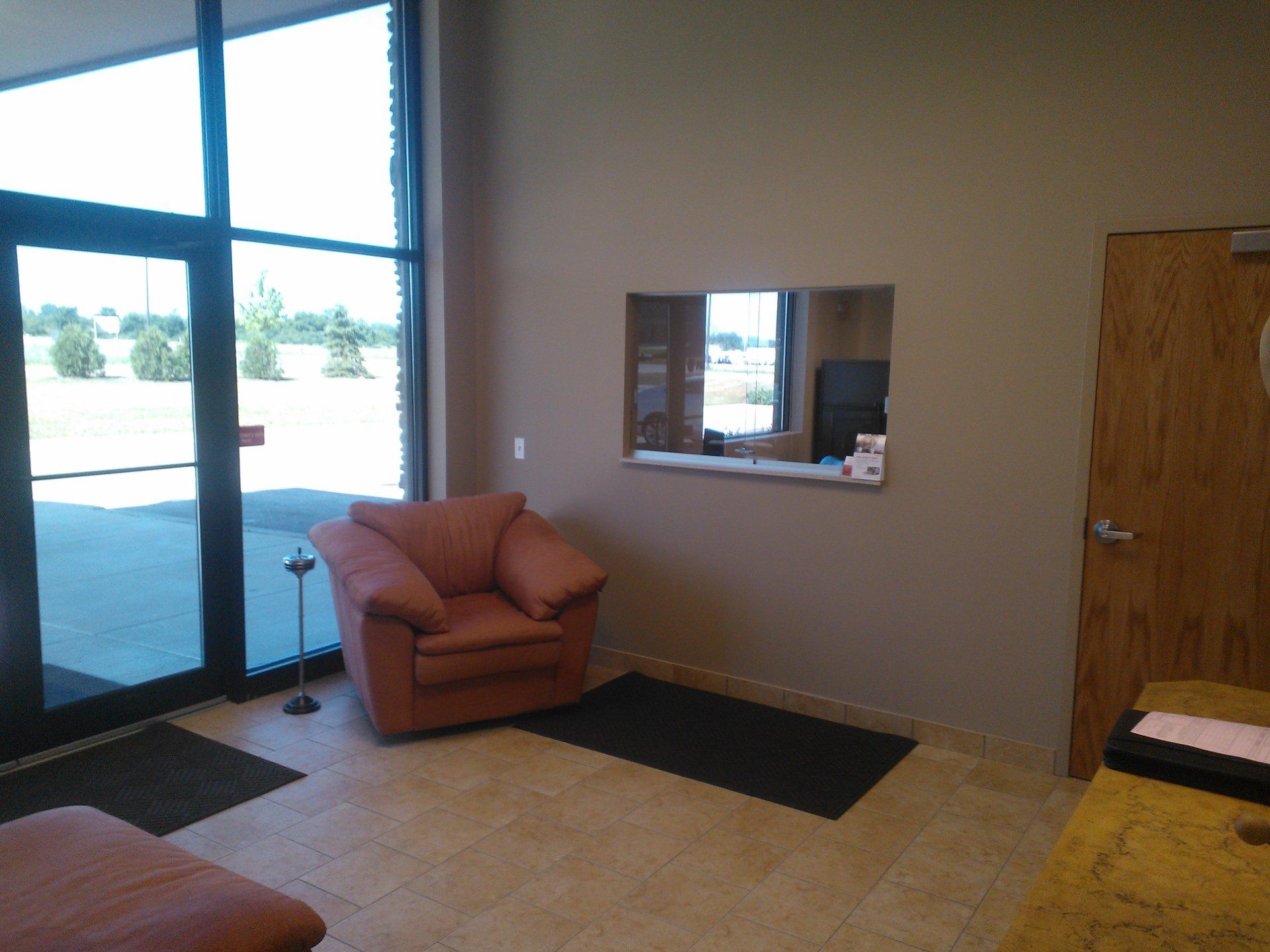 A waiting room with a chair and a window