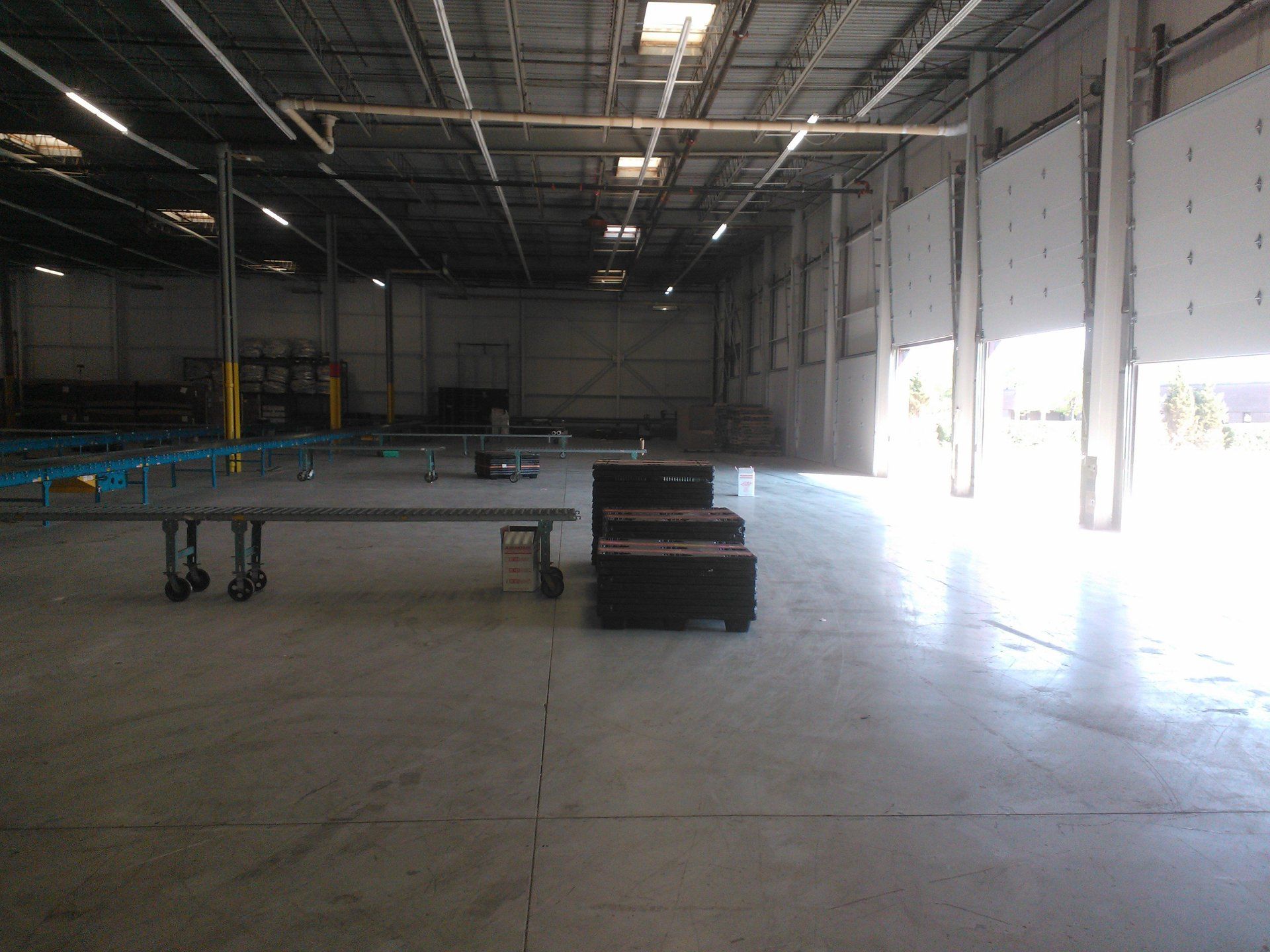 An empty warehouse with a table and chairs in the middle
