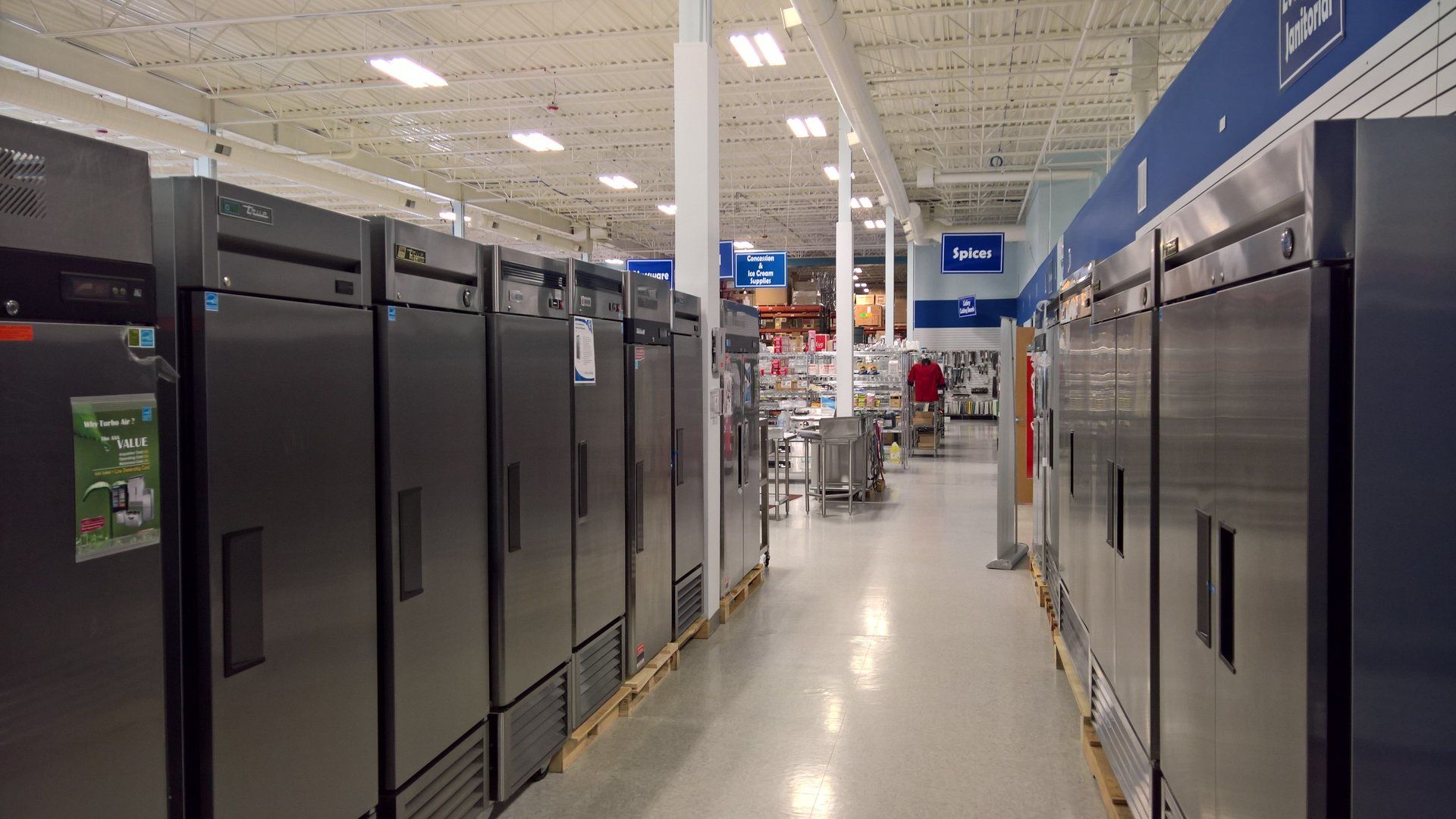 A row of refrigerators are lined up in a store.