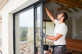 Glass Service — Man Installing Glass Door in House in Pleasanton, CA Glass Service — Man Installing Glass Door in House in Pleasanton, CA