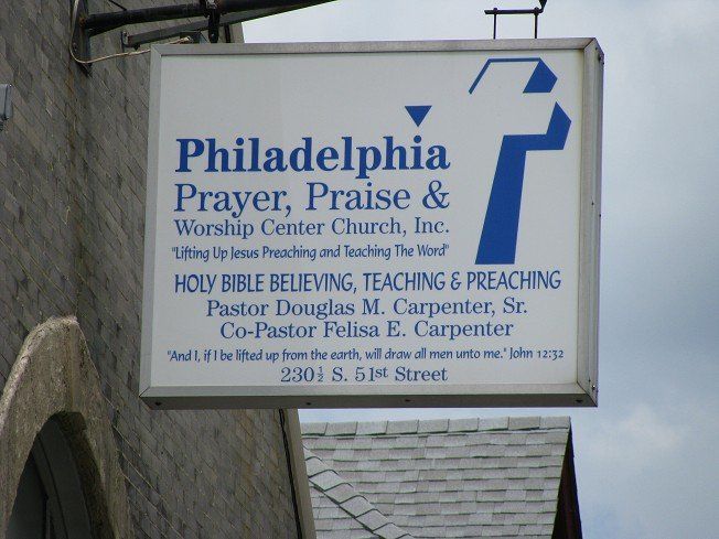 Sign for Philadelphia Prayer, Praise & Worship Center Church. Blue and white, with a cross and text.
