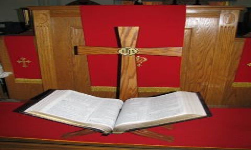 Cross on red altar with open Bible.