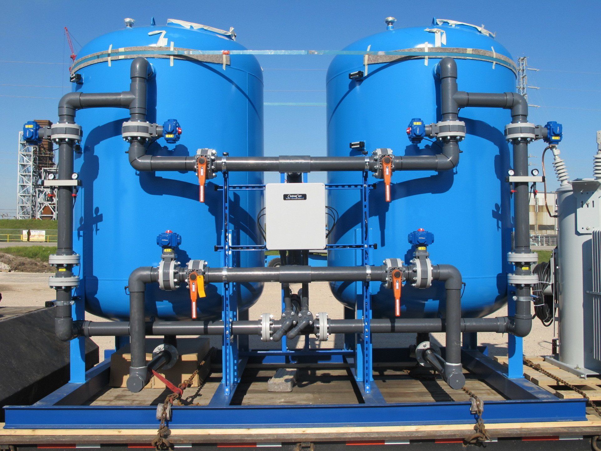 A row of blue tanks with pipes attached to them
