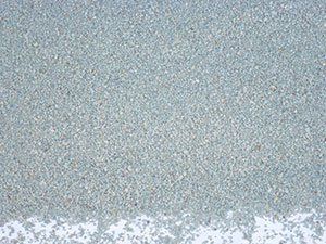 A close up of a gray sandy surface with a white border.