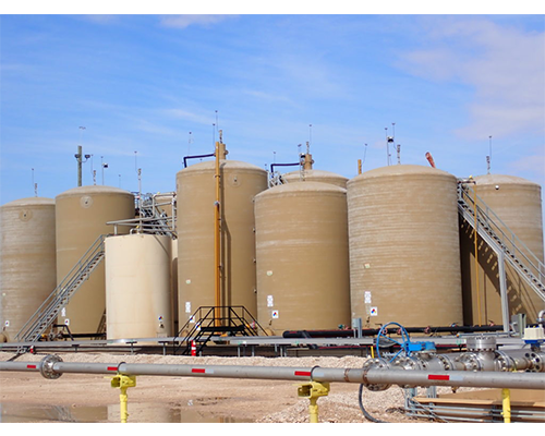 A row of large tanks with stairs leading up to them