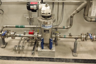 A bunch of pipes are connected to a machine in a room.