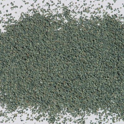 A pile of green sand on a white surface