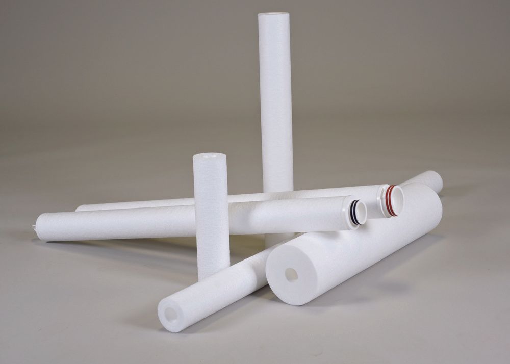 A group of white pipes are stacked on top of each other on a table.