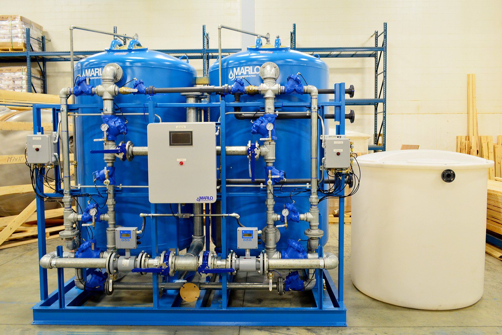 A blue and white machine is sitting next to a white tank in a room.