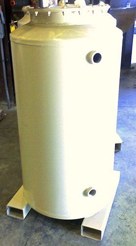 A large white tank is sitting on top of a concrete floor.