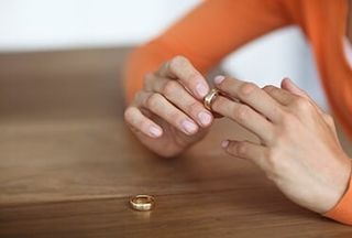 Woman removing her wedding ring — Divorce in Portland, ME Woman removing her wedding ring — Divorce in Portland, ME