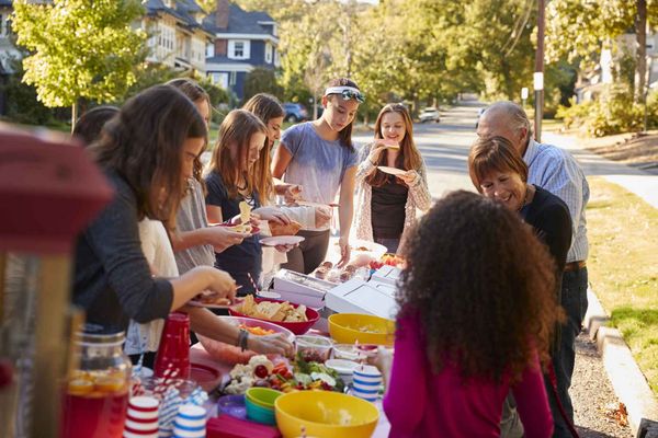 Neighbors Standing Around a Table and Having a Party — Athens, MI — AAA Sanitation