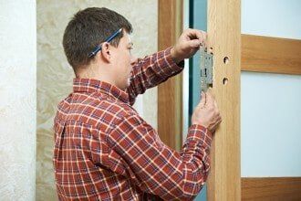 Man fitting door lock - lock company in Philadelphia, PA Man fitting door lock - lock company in Philadelphia, PA