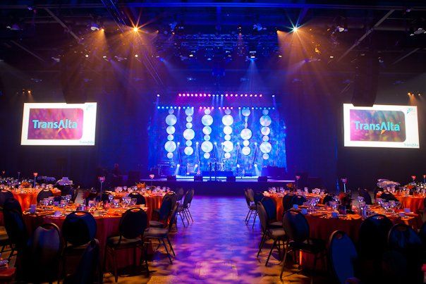 A large room filled with tables and chairs and a stage.