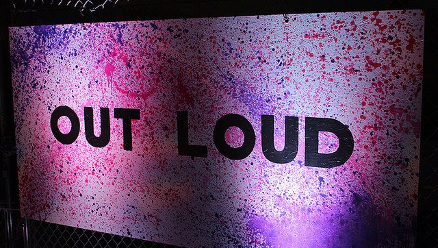 A sign that says out loud on a purple background
