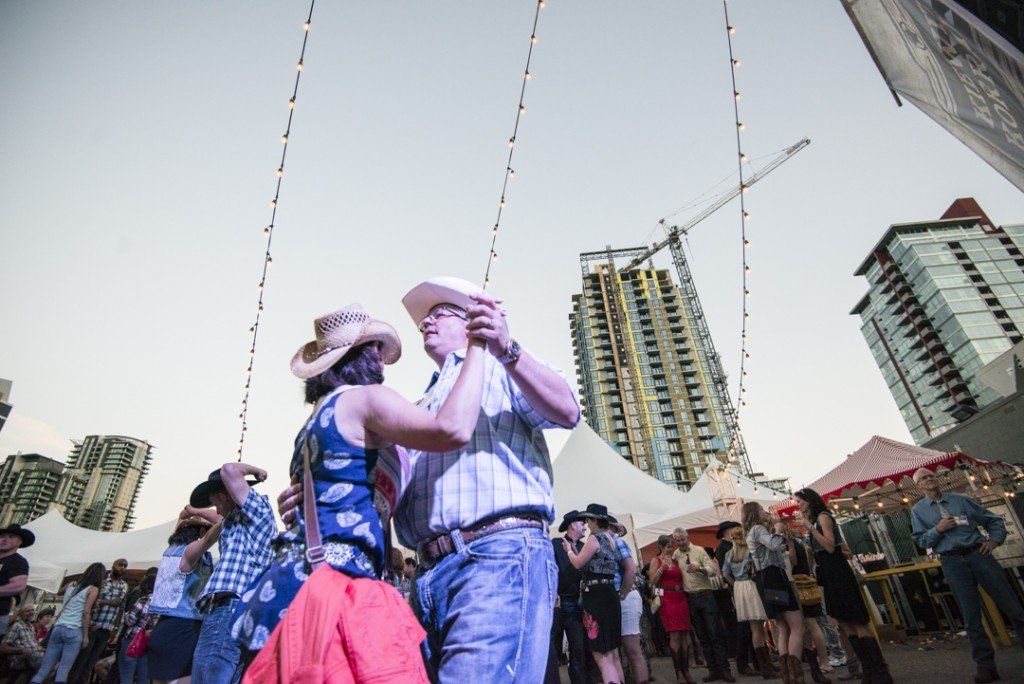 A man and a woman are dancing in front of a crowd of people.