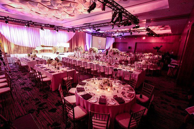 A large room with tables and chairs set up for a wedding reception.