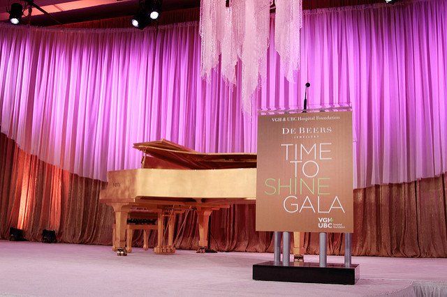 A stage with a piano and a sign that says `` time to shine gala ''.
