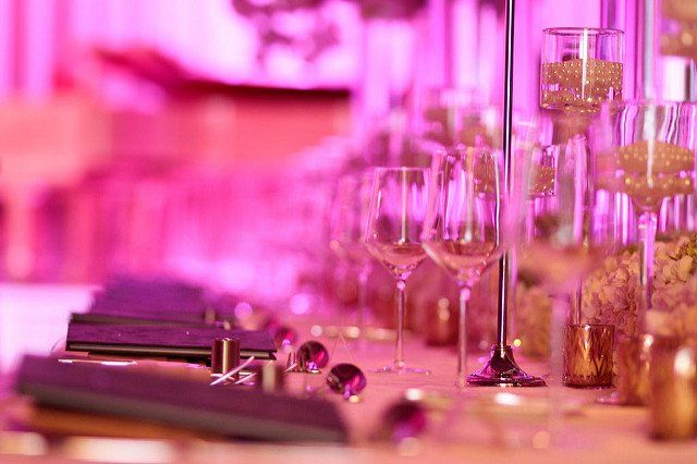 A table with a lot of wine glasses and candles on it.