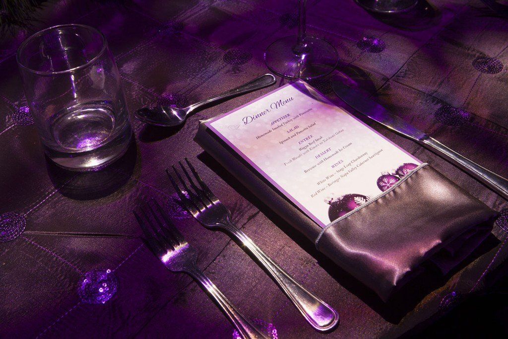 A menu is sitting on a table with silverware.