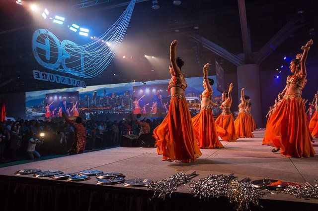 A group of women are dancing on a stage in front of a crowd.
