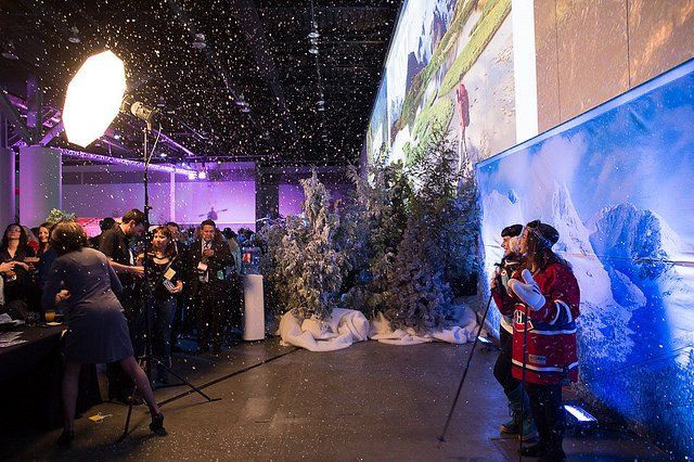 A group of people are posing for a picture in a room with snow falling from the ceiling.