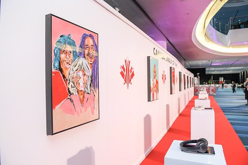 A painting of three women is hanging on a wall in a room.