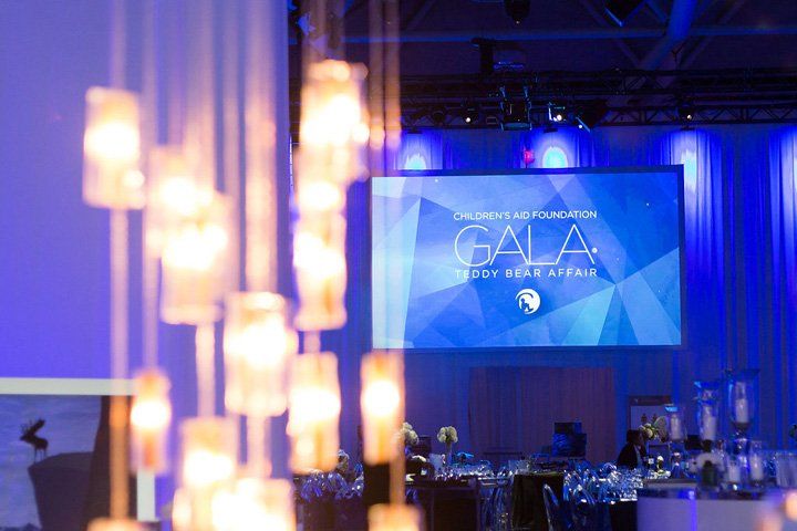 There is a large screen in the middle of the room that says gala.
