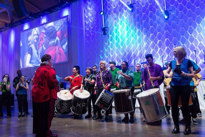 A group of people are playing drums on a stage.