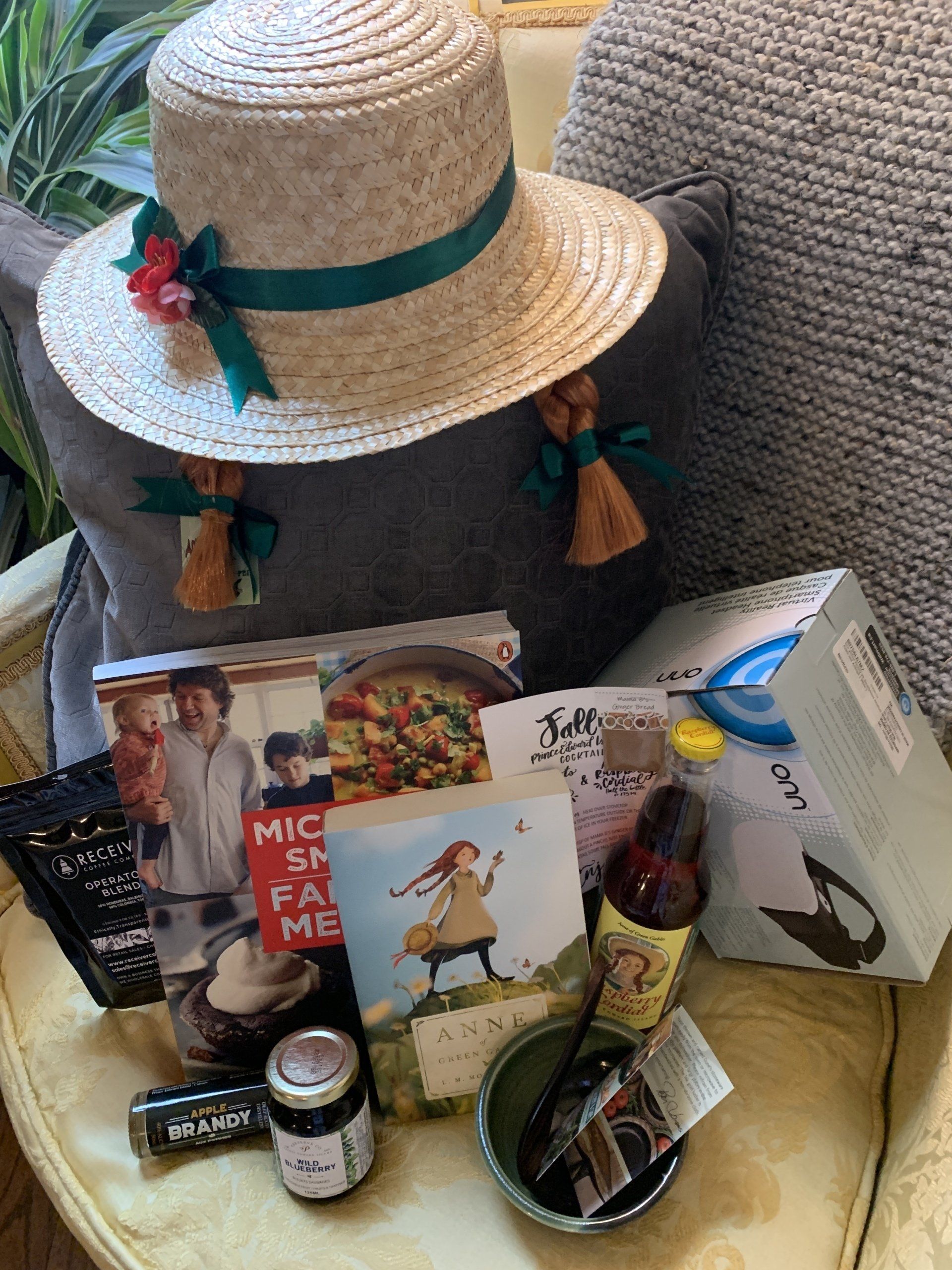 A straw hat is sitting on top of a chair next to a pillow.